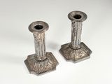 pair of antique silver candlesticks on a white background