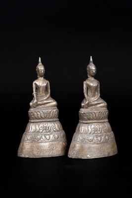 a pair of silver buddha statues sitting on top of each other