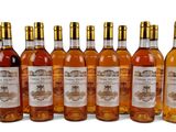 six bouteilles de vin posées les unes à côté des autres sur une surface blanche