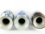 three blue and white vases sitting next to each other on a white surface