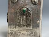 une vieille boîte en argent avec une pierre verte au milieu