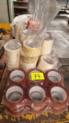 plusieurs rouleaux de ruban adhésif posés sur une table, à côté d'autres rouleaux de ruban adhésif