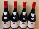 four bottles of wine are lined up on a wooden box