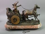 a bronze statue of a man on a horse drawn carriage
