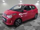 la petite voiture rouge est garée sur un sol en damier