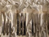 a lot of forks and spoons that are in a case