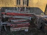 a pile of wood sitting in front of a yellow building