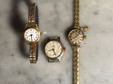 deux montres et un bracelet de montre posés sur une surface en marbre