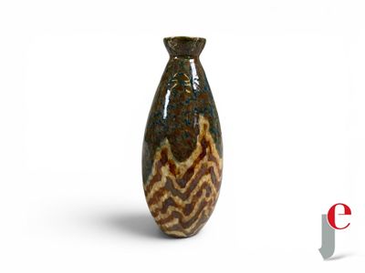 a brown and black vase sitting on a white surface