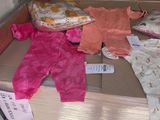 une pile de vêtements de bébé posée sur une boîte en carton