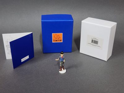 une petite figurine représentant un homme debout devant une cabine téléphonique bleue