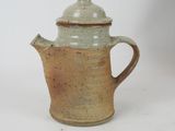 a small coffee pot with a lid on a table