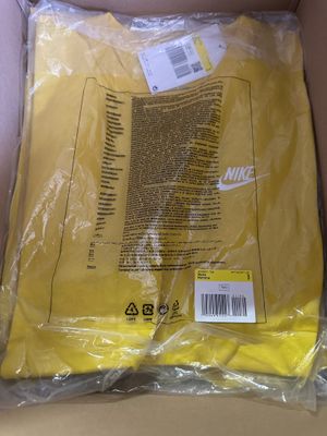 yellow nike t - shirt in a box with a price tag on it