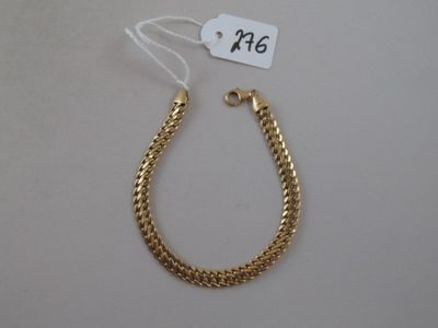 a close up of a gold chain bracelet with a price tag