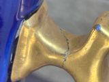 a close up of a blue vase with a gold handle