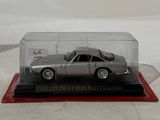 a silver model of a car in a glass case