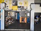 a garage with a car in it and a man working on a laptop