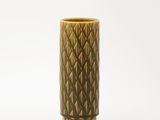 un vase marron orné d'un motif sur un fond blanc