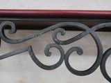 a close up of a metal bench with a bird on it