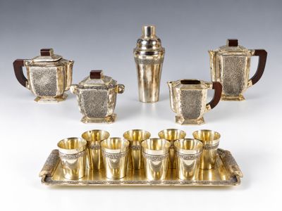 a silver plated tea set with four cups and a tray
