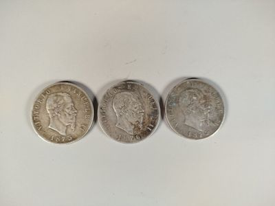 three silver coins sitting next to each other on a white surface