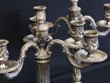 a silver candelier that has five candles on it
