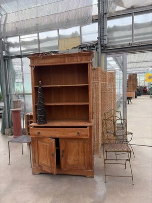 a wooden cabinet and a chair in a room