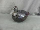 un petit oiseau en argent posé sur une table
