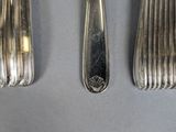 two forks and spoons are sitting next to each other on a table