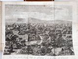 an old book with a drawing of a village in the middle of it