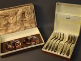 two sets of silverware in a box on a table