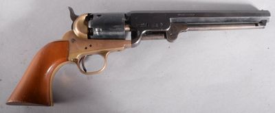 un vieux revolver avec une poignée en bois sur une surface blanche