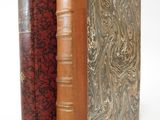 two books sitting side by side on top of a white surface
