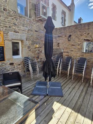 une terrasse équipée de chaises et d'un parasol