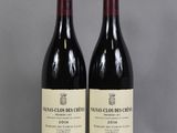 two bottles of wine sitting on top of a table next to each other