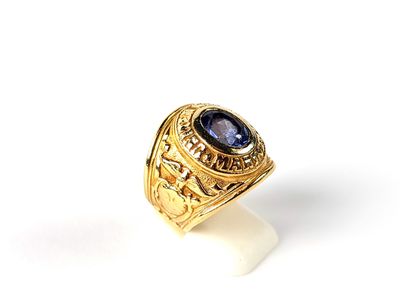 gros plan d'une bague en or avec une pierre bleue