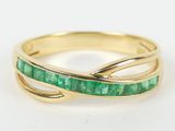 a close up of a gold ring with emerald stones