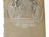 une plaque apposée sur la tranche d'un livre, sur laquelle figure l'image de deux hommes