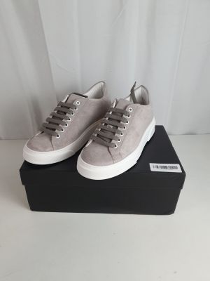 a pair of grey sneakers sitting on top of a black box