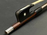 un archet de violon et un repose-archet posés sur une table
