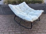 une chaise blanche posée sur un sol en briques