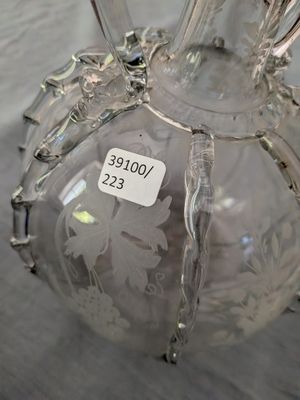 un vase en verre avec une étiquette dessus, posé sur une table