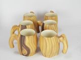 four wooden mugs sitting on a white surface with a white background