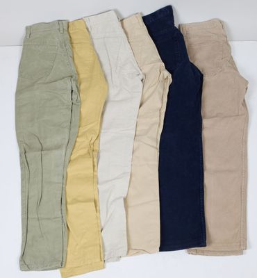 un lot de cinq paires de pantalons posées sur une surface blanche