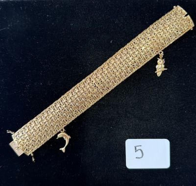 a close up of a gold bracelet on a black surface