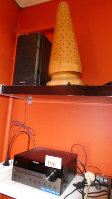 une étagère sur laquelle sont posés des haut-parleurs, une lampe et un haut-parleur