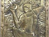 a close up of a metal plaque with a person holding a baseball bat