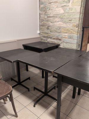a table and two chairs in a room with a stone wall