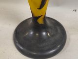 a close up of a vase with a woman on it on a black base