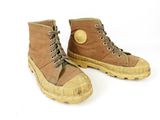 pair of brown boots on a white surface with a white background